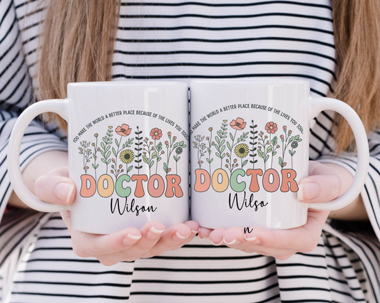 Personalized ceramic mug with colorful floral design and the word “Doctor” in bold letters, customized with name, ideal thank you or graduation gift for female doctors
