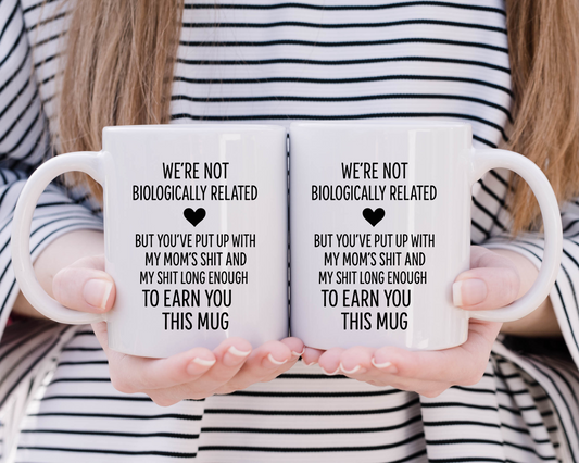 Funny white ceramic mug with text “We’re Not Biologically Related… But You’ve Put Up With My Mom’s Sh*t” – gift for stepparent